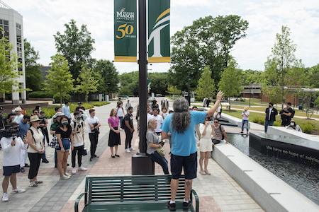 man gives a tour of Wilkins Plaza to group of students