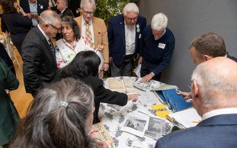 people looking at objects on table