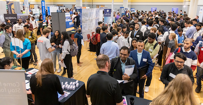 large groups of students checking out booth at a career fair