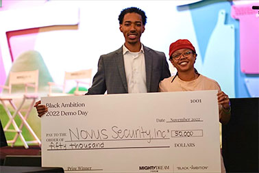 Founders of Novus Inc. people holding cardboard check