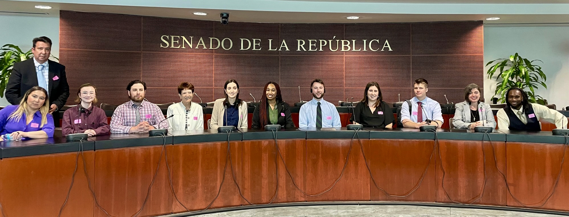 Students sit with members of the Mexico Senate inside the senate room.