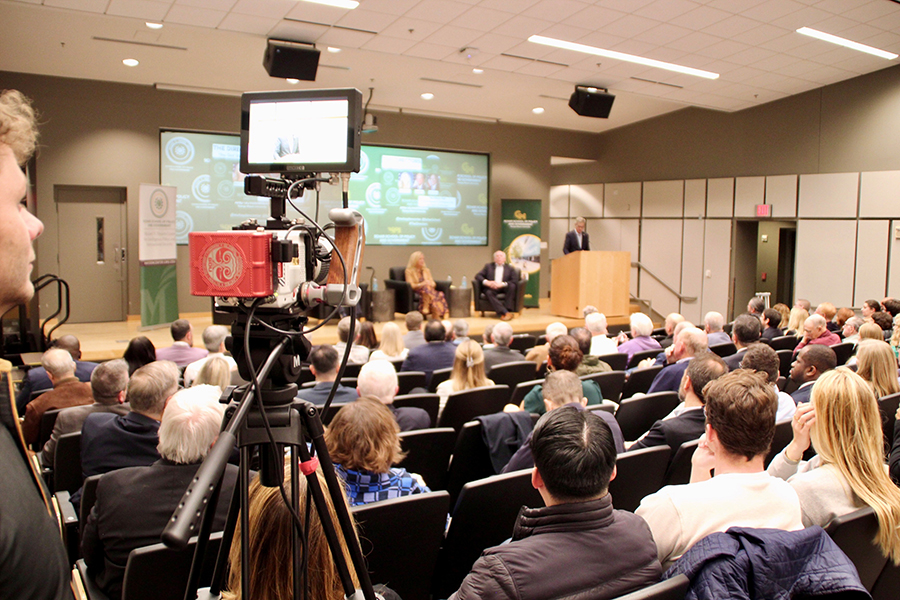 A television camera is in the foreground as it tapes a panel discussion.
