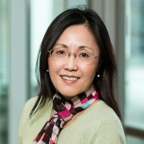 A woman with dark hair smiles at the camera.