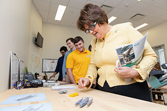 Mason's Interim President Anne Holton looking at 3D renditions of boats. 