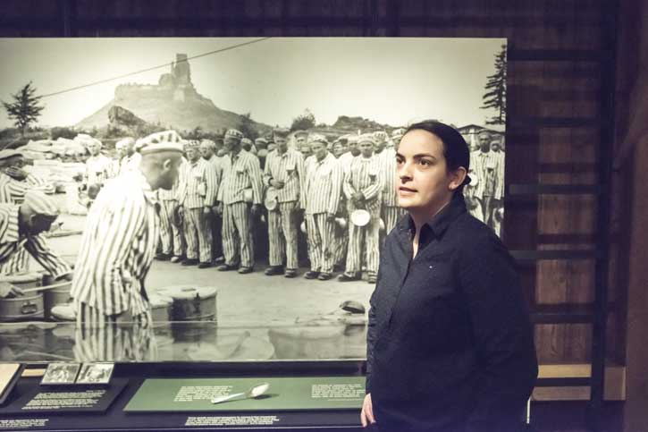 Zeljana Varga stands in front of a photo at the Holocaust Museum