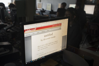 A computer monitor in the classroom shows Inklewriter, the program students use to tell stories.