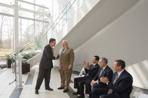U.S. Senator Mark Warner, Virginia, shakes hands with Kenneth Ball, Dean, Volgenau School of Engineering, after he spoke at the Cyber Security/Engineering Program ribbon cutting for the Volgenau School of Engineering at the Long and Kimmy Nguyen Engineering building at the Fairfax Campus. Applauding (L to R) are Provost David Wu, President çngel Cabrera, and Mike Papay, CTO Northrop Grumman. Photo by Alexis Glenn.