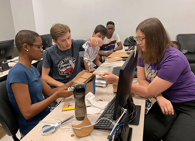 Students use common household items like cardboard, hot glue, and tape to test their water proofing skills and learn about civil engineering concepts. Photo by Ryley McGinnis.    