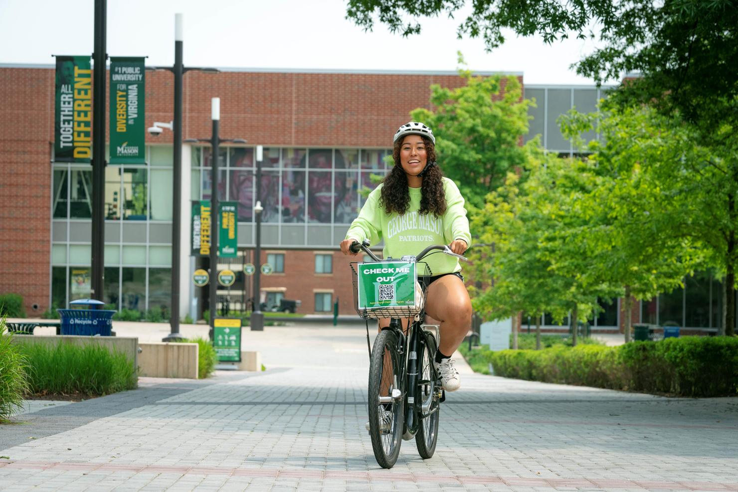 Woman riding a bike on George Mason University's Fairfax Campus