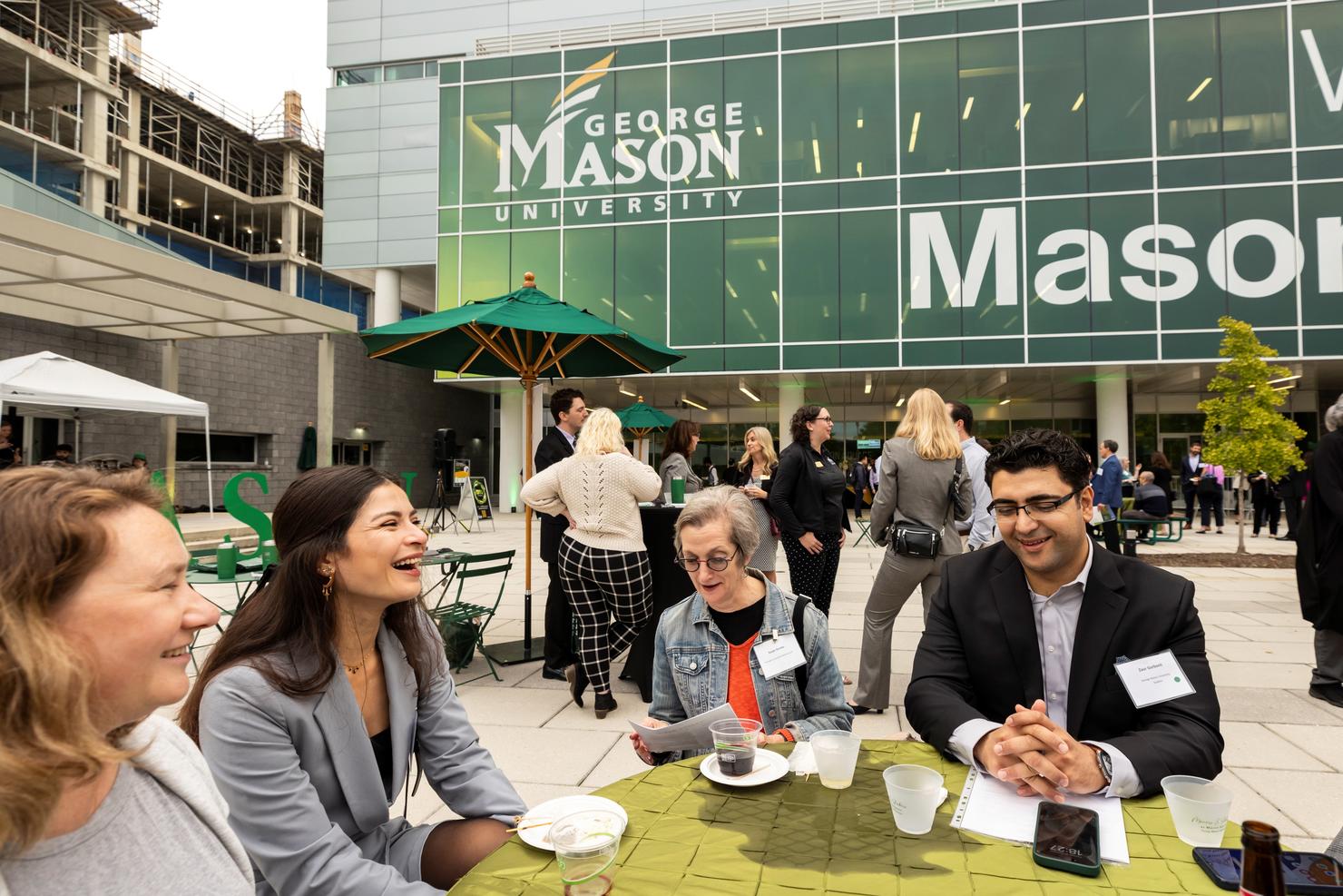 A group of people gather together for conversation on the plaza at Mason Square