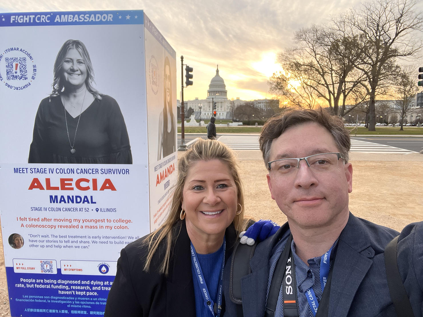 Evan Cantwell and a fellow volunteer on the National Mall in front of the photo exhibit for colorectal cancer awareness and the U.S. Capitol