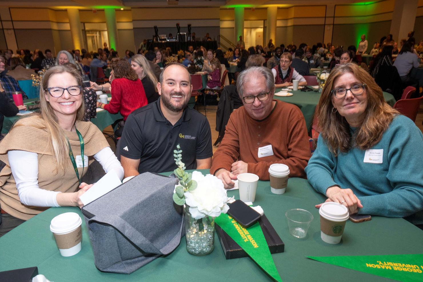 Faculty and staff sit together at a table during Green Day breakfast