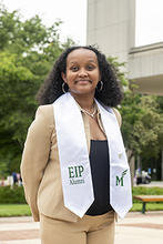 Kalkidan Negussie stands outside wearing her EIP stole and a tan pants suit