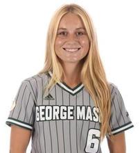 A woman with long blonde hair in a green and gray sports top with the number 6 on it smiles for the camera.