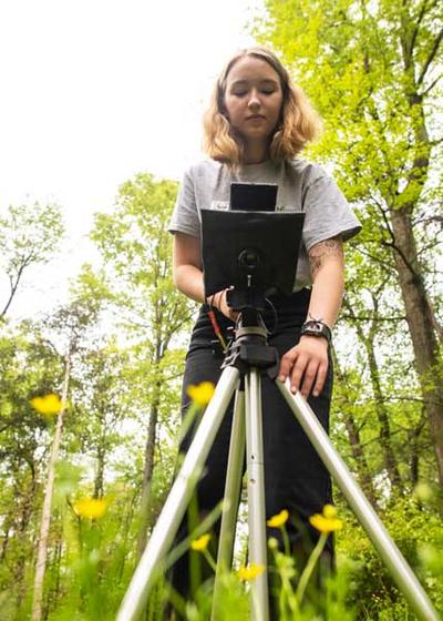 Mason student, Anna Siegle, uses special macro lens camera equipment to photograph wildflowers