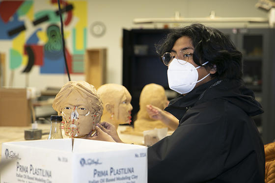A student works on a clay self-portrait in its early stages in the Forensic Sculpture class. 