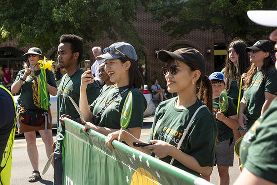 Members of Patriot Nation hold the Mason 50th banner and walk in the Independence Day Parade