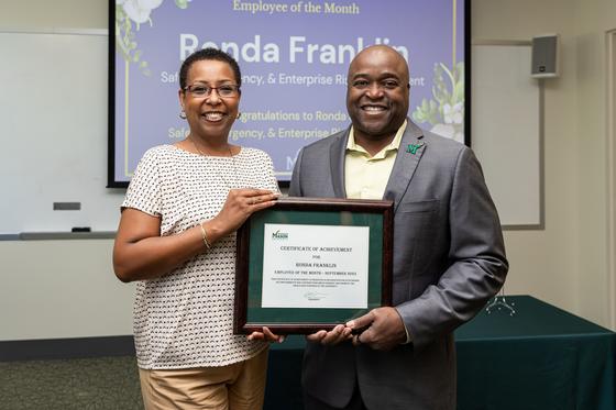 Ronda Franklin and Gregory Washington smile for the camera and hold Ronda's certificate of recognition