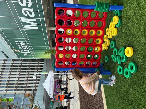 Child plays a game on the plaza at Mason Square