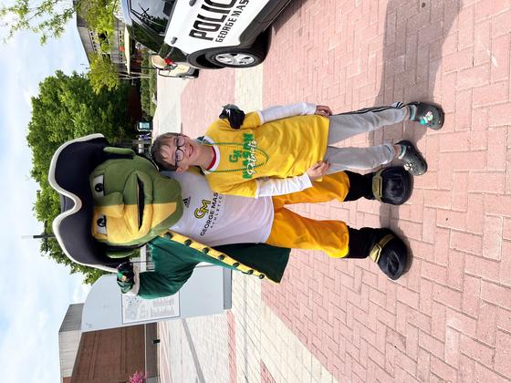 Child stands with the Patriot mascot