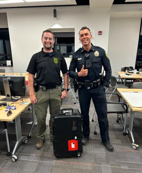 George Mason Police Corporal Blaine Ries delivers a Starlink system to a member of the Asheville, North Carolina, police department headquarters