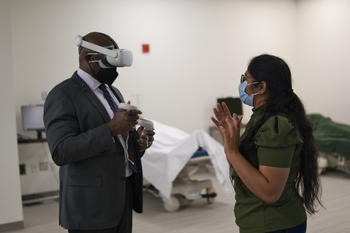 Image of Sindhu Mallala showing President Gregory Washington the VR simulation technology 