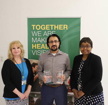 Image of Rehan Saeed with award beside of Maria Uriyo and Brenda Sheingold