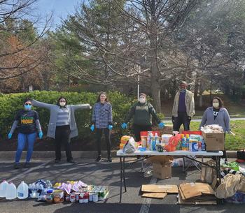 BSW Seniors standing in front of donated food, clothing, and non-perishable items at a donation drive