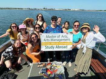 Students on boat in front of water