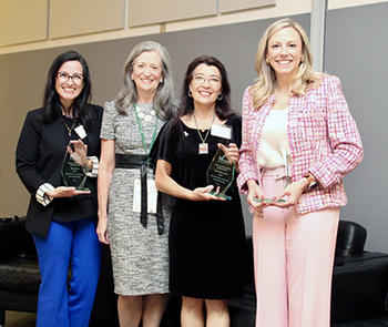 Four women stand facing the camera.